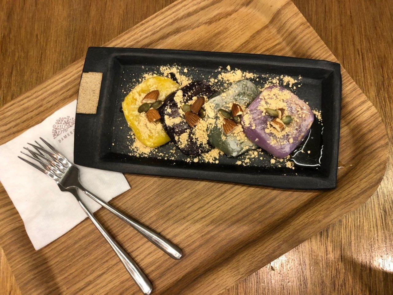 篱笆边的菊花咖啡厅四种颜色豆糕美味展示，撒上豆粉与坚果，色彩丰富，口感独特。